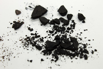 This is a photograph of a Black powder Eyeshadow isolated on a White background