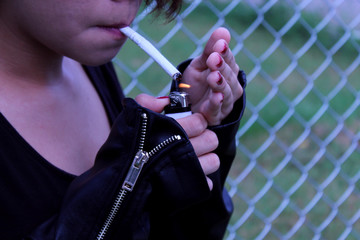 Chica joven encendiendo un cigarro 