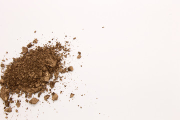 This is a photograph of a Brown powder eyeshadow isolated on a White background