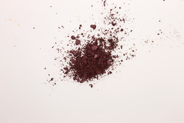 This is a photograph of a Berry Red powder Eyeshadow isolated on a White background