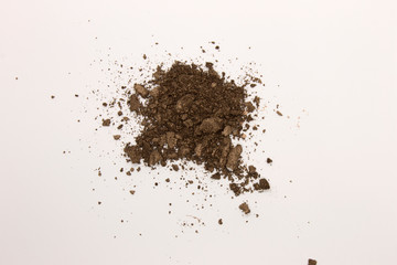 This is a photograph of a Dark Brown powder Eyeshadow isolated on a White background