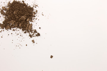 This is a photograph of a Dark Brown powder Eyeshadow isolated on a White background