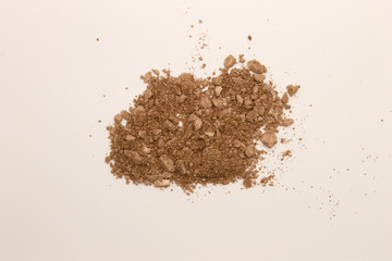 This is a photograph of a Copper powder Eyeshadow isolated on a White background