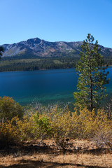 Fototapeta na wymiar Vertical photo of mountains in the background and a mountain lake with fall colors in the foreground