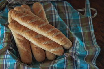 Baguette bread on a wooden table cloth.