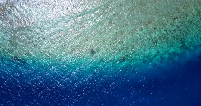 Beautiful wallpaper of paradise shore with blue turquoise colors from a top view video in Chagos Archipelago