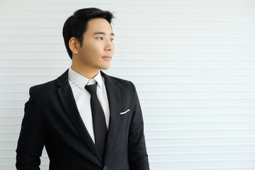 Young businessman is wearing a black suit be a smile and standing smart poses,Intelligent and confident people,Successful leader,Management,company.