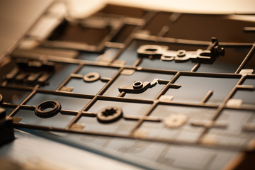a macro, shallow focus view of a plastic grid of parts for a model toy to assemble