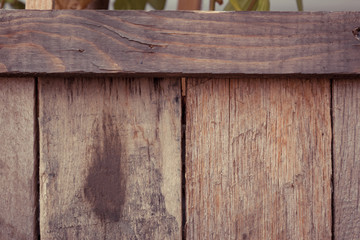 Detail of a wooden planter made from recycled wood than has been stained a dark varnish