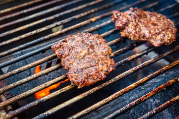A closeup of hamburgers on a grill.