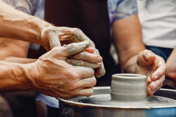 Potter make a small jug. Hands of a potter at work