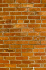 Deteriorating old red clay brick wall texture with stray shadows