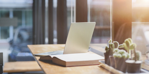 Cropped shot of modern workspace with laptop computer with office supplies