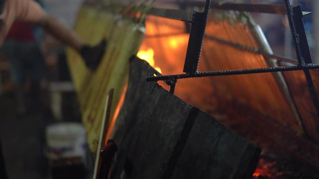 Process of cooking a traditional Malaysian food "Lemang" is made of glutinous rice, coconut milk and salt, cooked in a hollowed bamboo stick lined with banana leaves