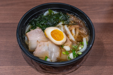 Bowl of delicious Japanese Udon noodles soup on table