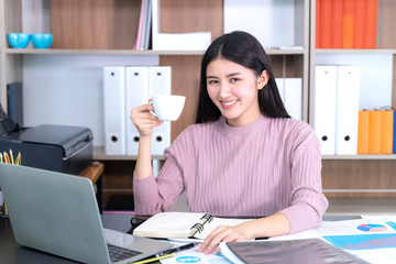 Obraz na płótnie Canvas lifestyle beautiful Asian business young woman on office desk hot coffee cup on hand , business concept.