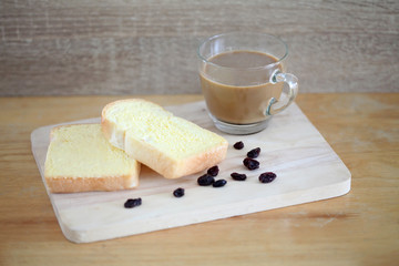 Toast and butter with hot coffee on wooden background