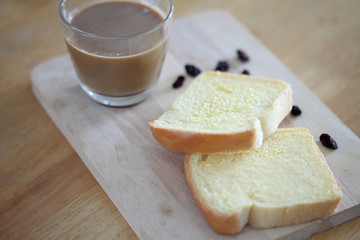 Toast and butter with hot coffee on wooden background