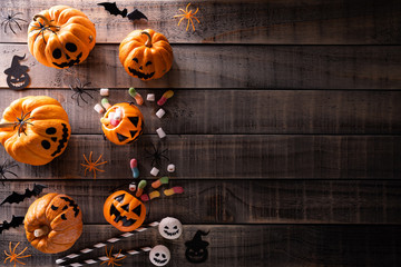 Top view of Halloween crafts, orange pumpkin, white ghost, bat and spider on dark wooden background...