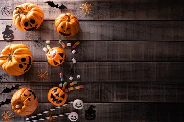 Schilderijen op glas Top view of Halloween crafts, orange pumpkin, white ghost, bat and spider on dark wooden background with copy space for text. halloween concept. © Siam