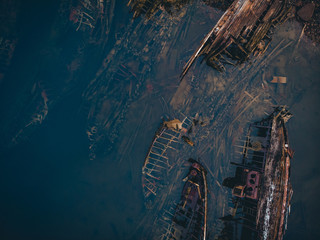 Cemetery of old ships Teriberka Murmansk Russia, wooden remains of industrial fishing boats in sea. Industrialization concept. Aerial top view