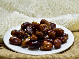 Date palm in the white plate on a sackcloth.In palm.