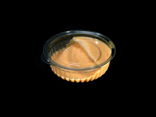 sauce in disposable dishes isolated on black background