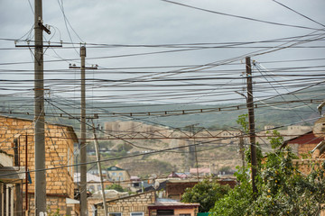 Power line post with electrical wires and capacitors isolated on blue sky background. Electricity...