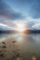 Lake wanaka during sunset in long exposure shot with snowcap mountain in the background.New Zealand road trip.