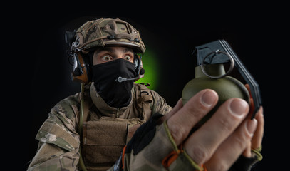 a male soldier in military clothes with a weapon on a dark background