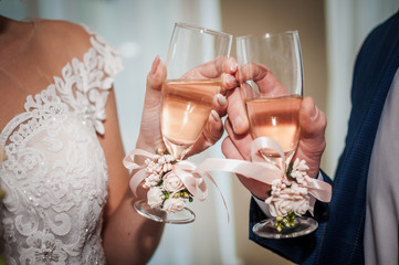 bride and groom clink glasses with champagne