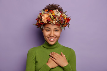 Candid shot of attractive smiling woman feels thankful, promises be loyal, appreciates pleasant...
