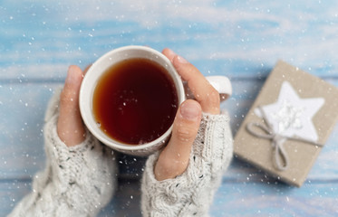 cozy winter tea party. a mug of tea in the girls hands. 