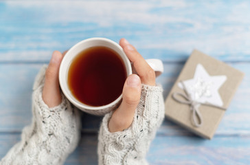cozy winter tea party. a mug of tea in the girls hands. 