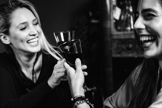 Drinking Red Wine. Young Women Toasting With Red Wine