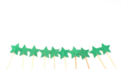 white Christmas background with green shiny skewers stars on white background