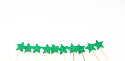 white Christmas background with green shiny skewers stars on white background