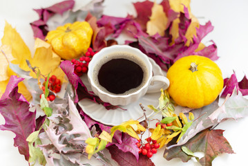 Autumn coffee time. Autumn leaves, pumpkins and berries on white table. 