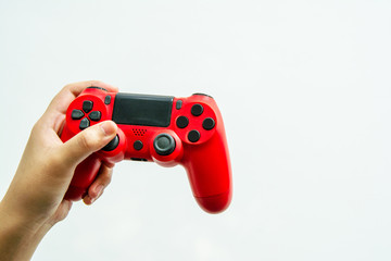 Left hand holding a red joystick © Thanaphon