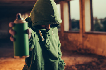 Graffiti artist pointing the spray to camera