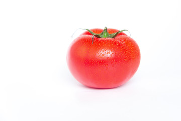 A ripe red tomato with water drops isolated on a white background