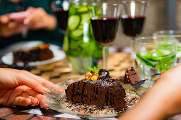 Waiter bringing a plate with raw cake to Female Friends.
