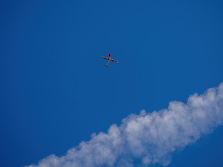 Little plane flying above us during summer day. Wonderful clear blue sky and interesting cloud formation