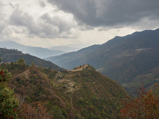 Harvested rice terraces on a hill in a remote village in the Himalayas. Cloudy autumn day. Nepal