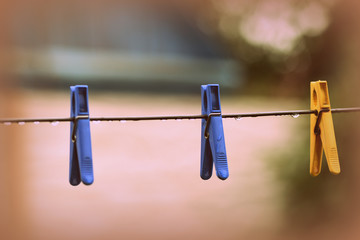 Plastic clothespins on wet wire after rain in the backyard close-up. Retro style