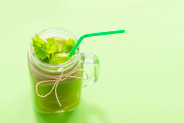 fresh celery juice in a jar on green background. concept of healthy food and detox