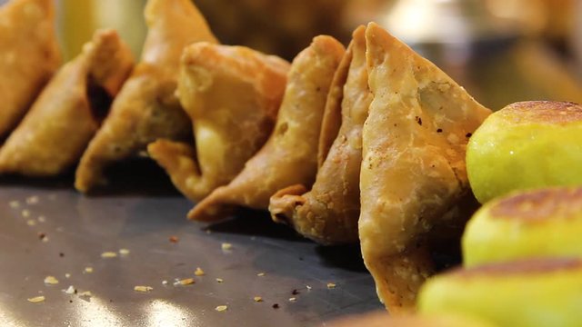 Closeup footage of popular Indian fast food snack, Samosa, a fried or baked dish with a savoury filling, such as spiced potatoes, onions, peas, or lentils. It is served with Chutney or Pav, loaf bread