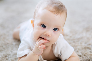 Cute Caucasian girl baby crawling on the carpet