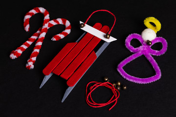 Pipe Cleaner Craft Candy Canes and an Angel, with a craft Stick sled Ornament with some red craft cord and tiny jingle Bells. Holiday crafts are a tradition for many families.