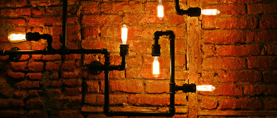 Edison Lamp and copper tubes on the dark background in the cafe in Tbilisi Georgia on October 2019.